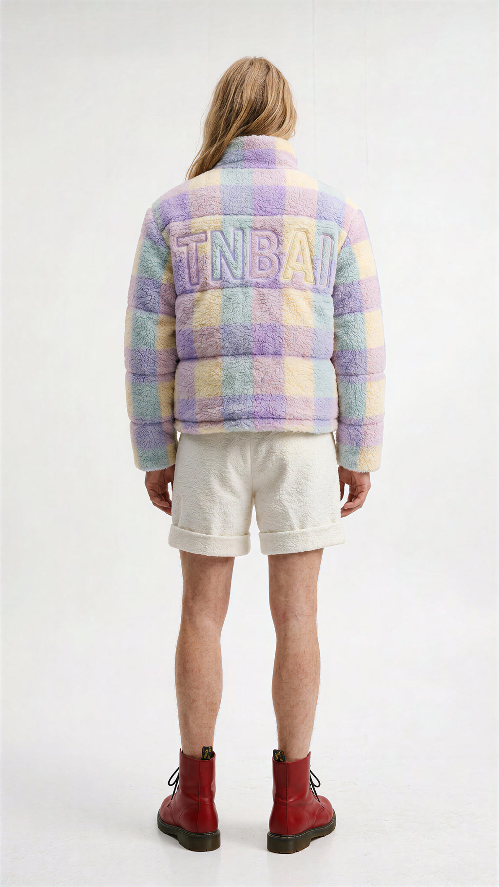 View from the back. On the jacket, make a 'TNBAI' white with outline like baseball embroidery.